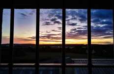 Sonnenuntergang mit Blick aus einem vergitterten Haftraumfenster